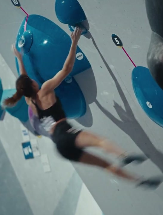 A climber launches between blue holds
